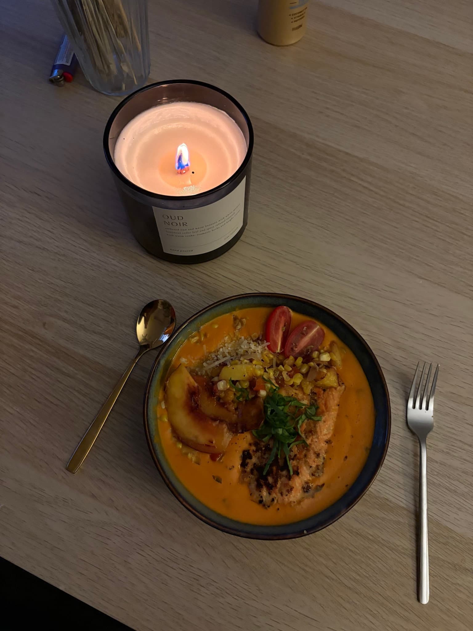 A warm plated dish beside a glowing candle